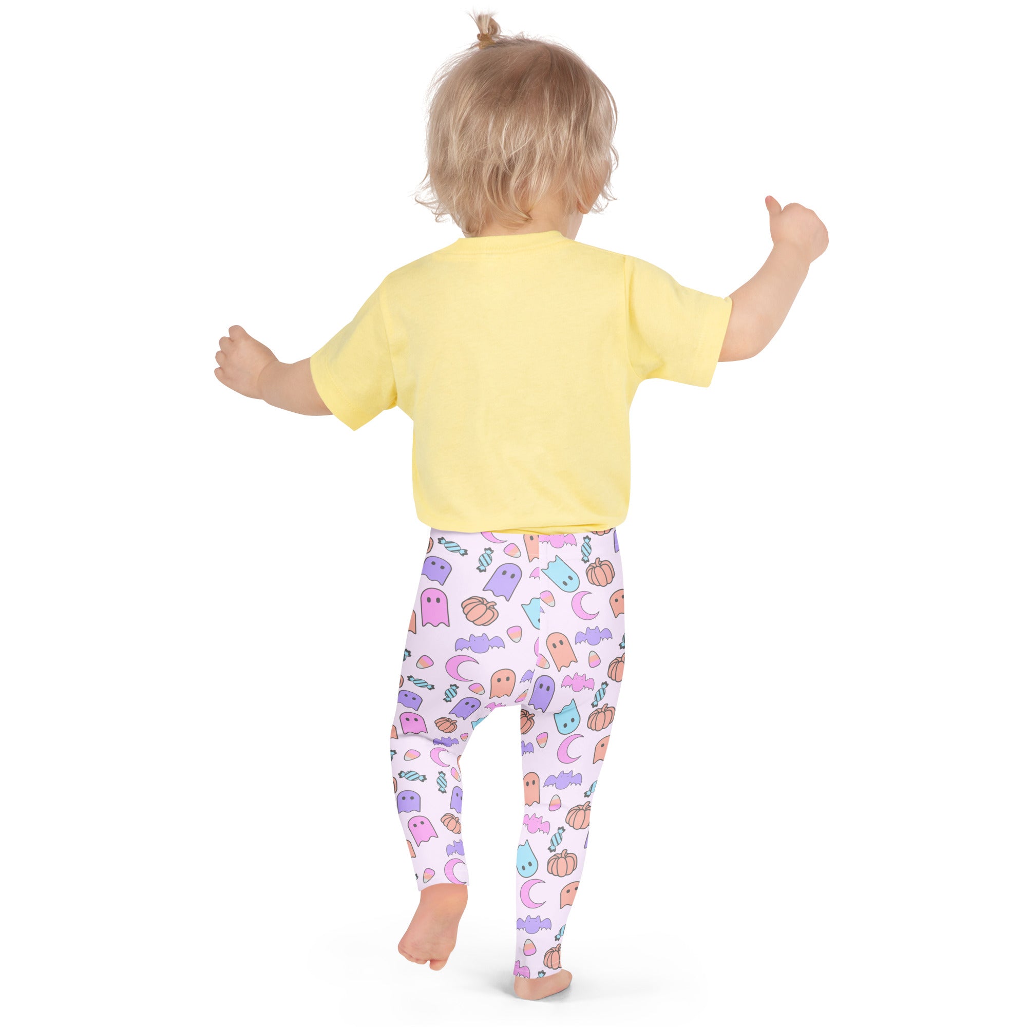 A child wearing buttery soft white girls Halloween leggings with colorful pastel ghost pumpkin bat and moon patterns