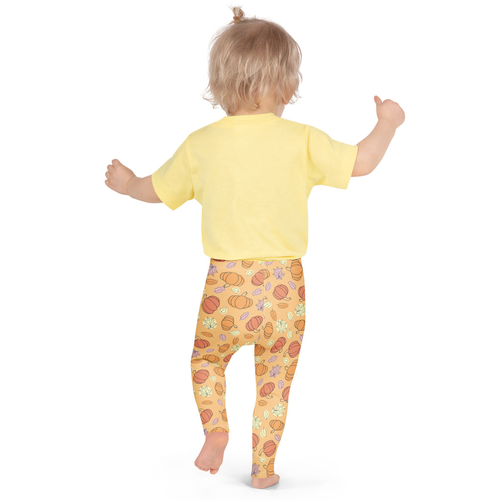 Kids pumpkin patch buttery soft leggings in orange with pumpkin patterns paired with a yellow short-sleeved top