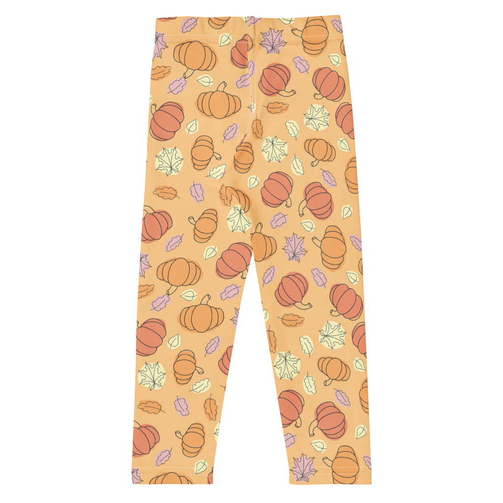Kids pumpkin patch buttery soft leggings in orange pumpkin and leaf pattern on a light peach background