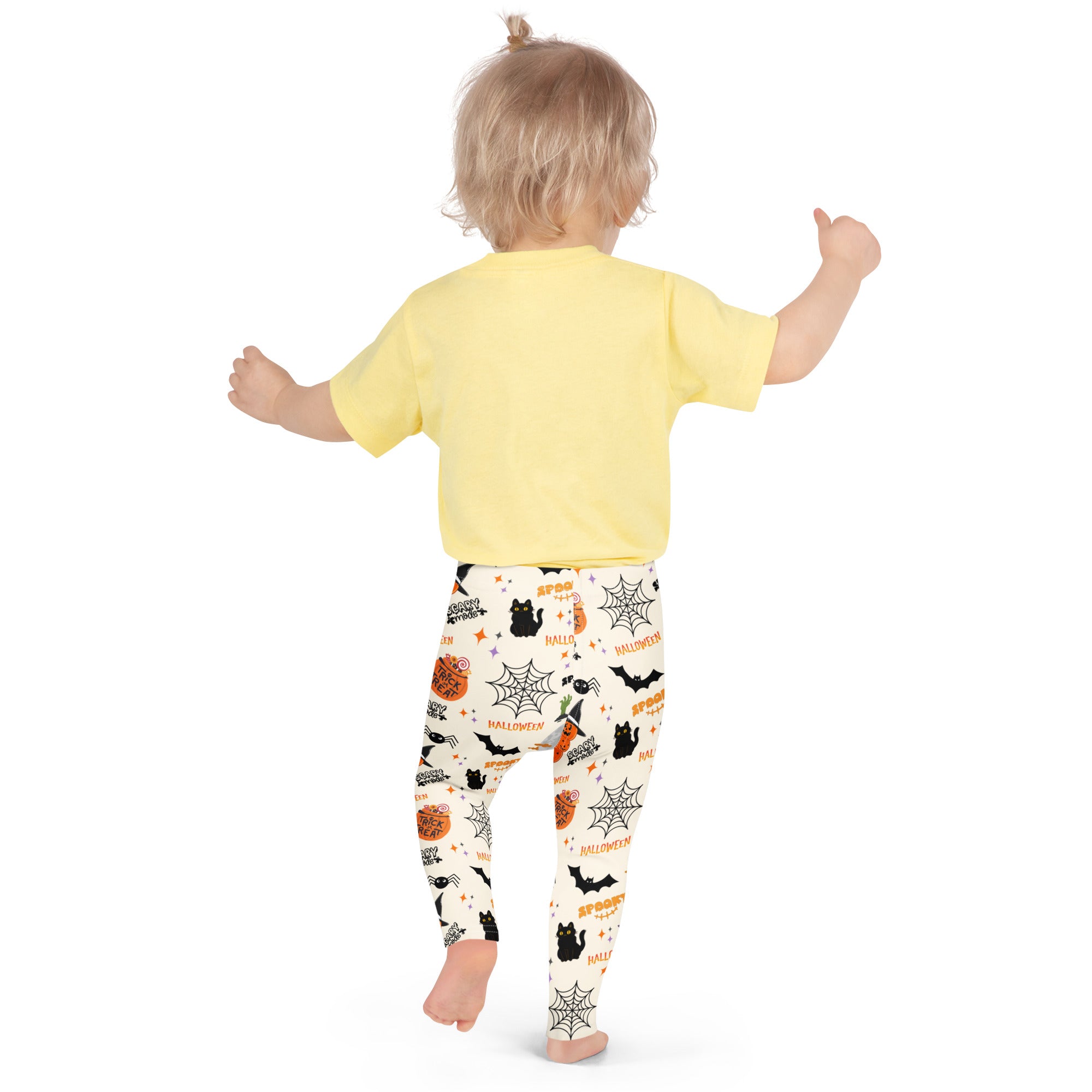 A child wearing kids trick-or-treat halloween buttery soft leggings with black bats pumpkins and spiderwebs on off-white background