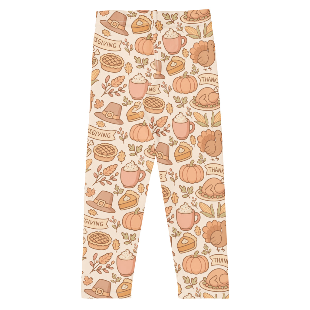Cream-colored kids thanksgiving buttery soft leggings with playful pumpkins pies turkeys and pilgrim hats pattern
