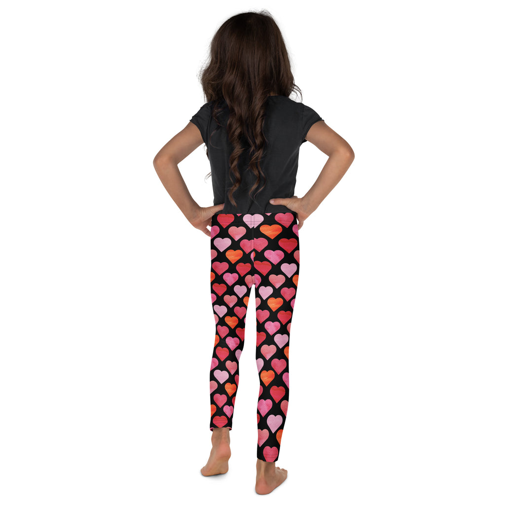 Girls black heart buttery soft leggings featuring a vibrant pink red and orange heart pattern on black fabric