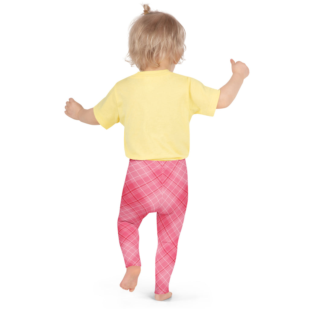A toddler wearing girls pink plaid buttery soft leggings in pink plaid with a yellow short-sleeved shirt