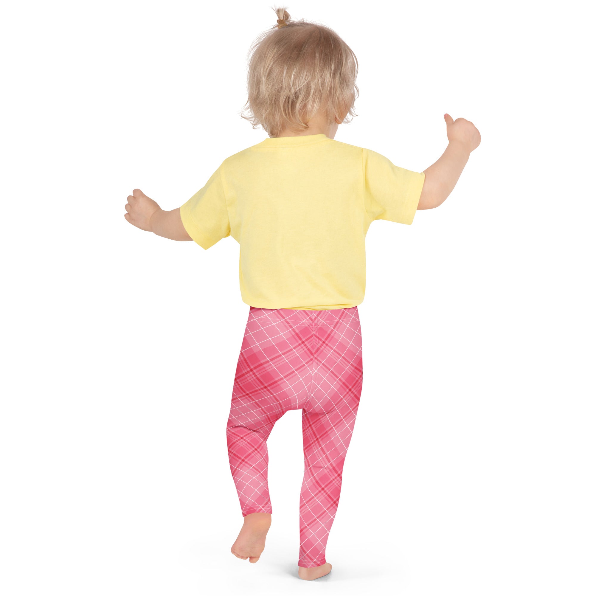 A toddler wearing girls pink plaid buttery soft leggings in pink plaid with a yellow short-sleeved shirt