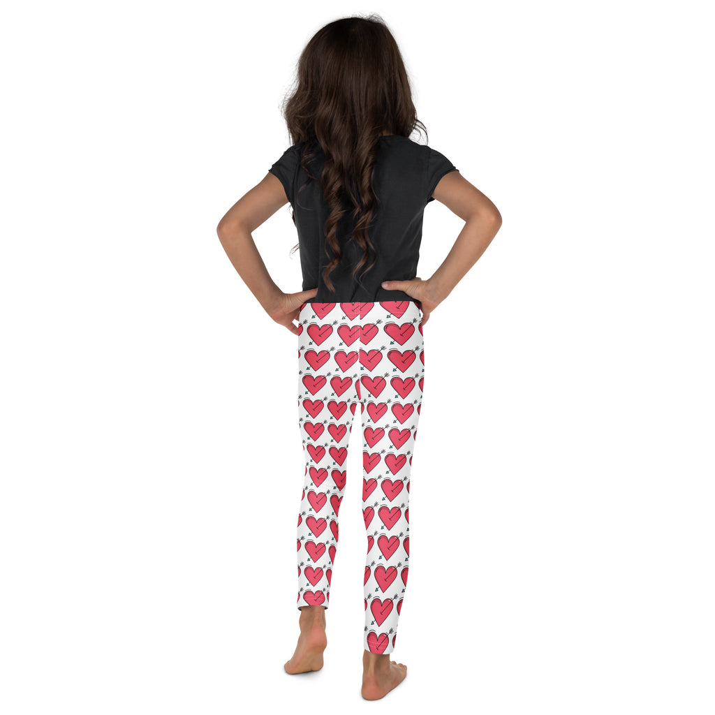 White girls buttery soft leggings with vibrant pink hearts and black outlines perfect for valentine’s day