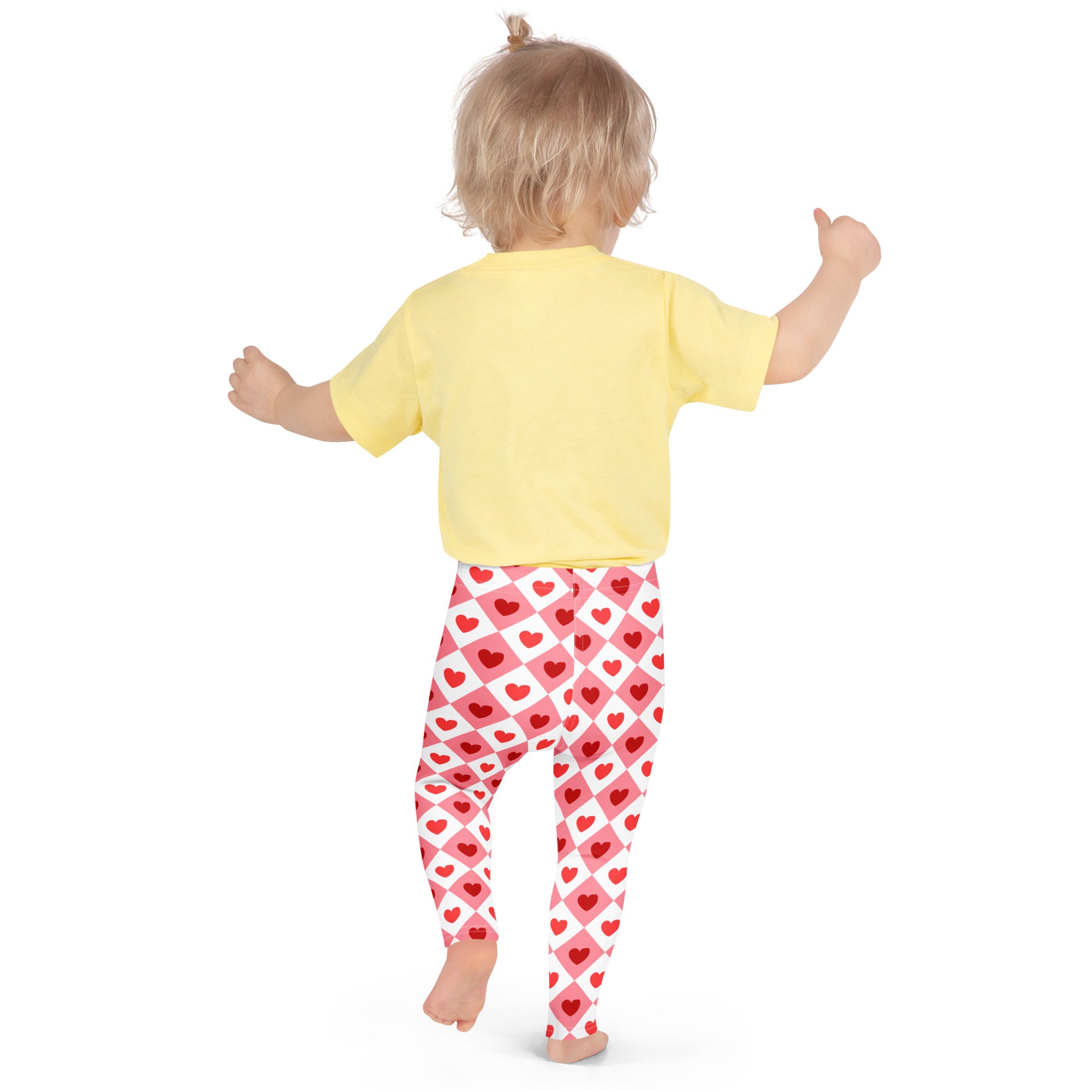 A child wearing girls pink argyle heart leggings buttery soft red and white heart patterned leggings and a yellow shirt
