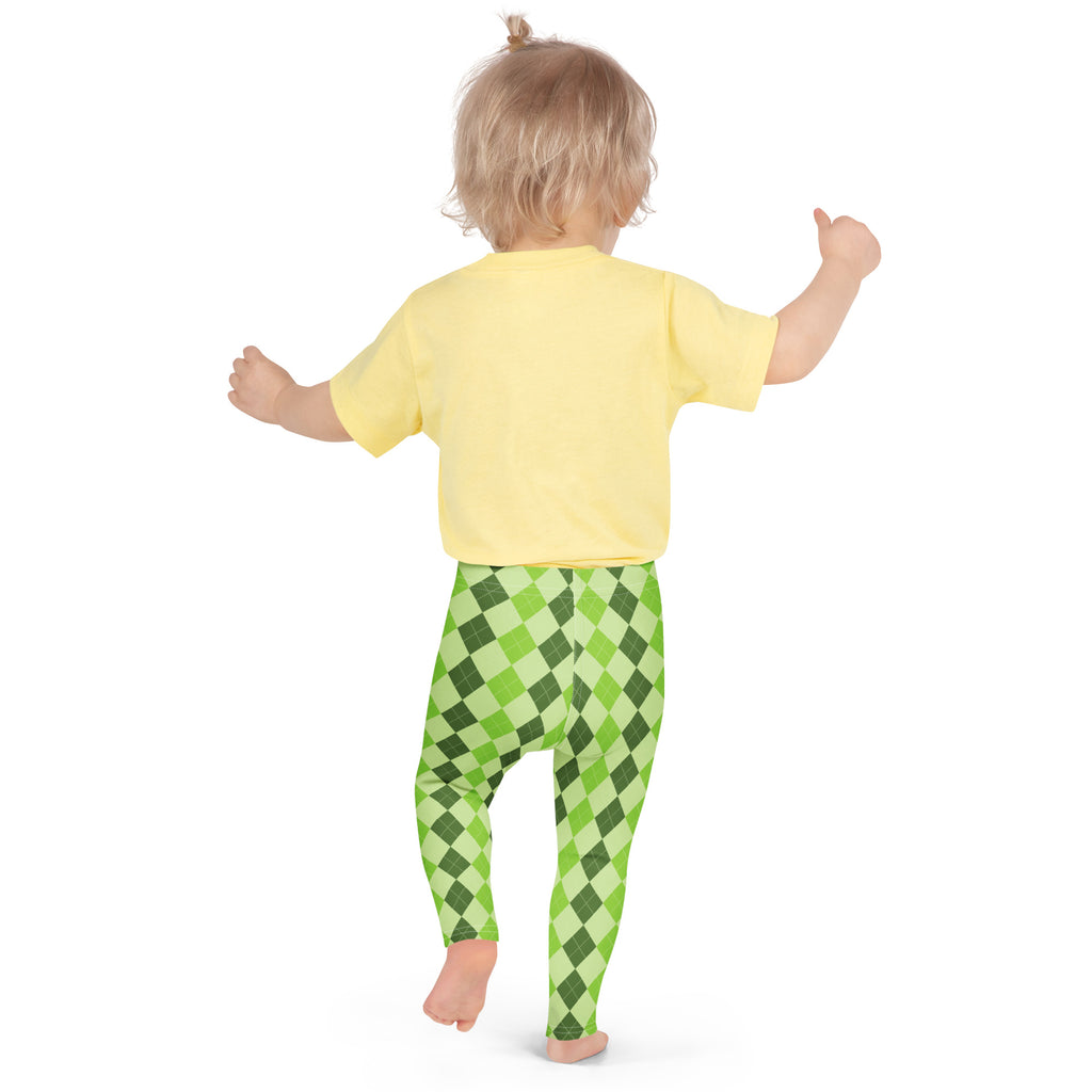 A child wearing girls light green argyle buttery soft leggings and a yellow short-sleeved shirt standing front view