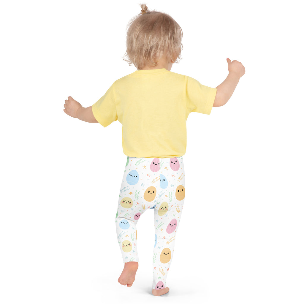 A child wearing girls cute Easter egg buttery soft white leggings with colorful smiling potato prints and a yellow top