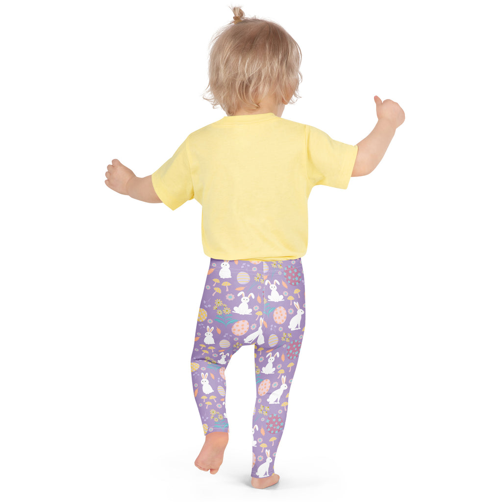 A child wearing girls purple Easter bunny buttery soft leggings with white bunnies eggs mushrooms and flowers design