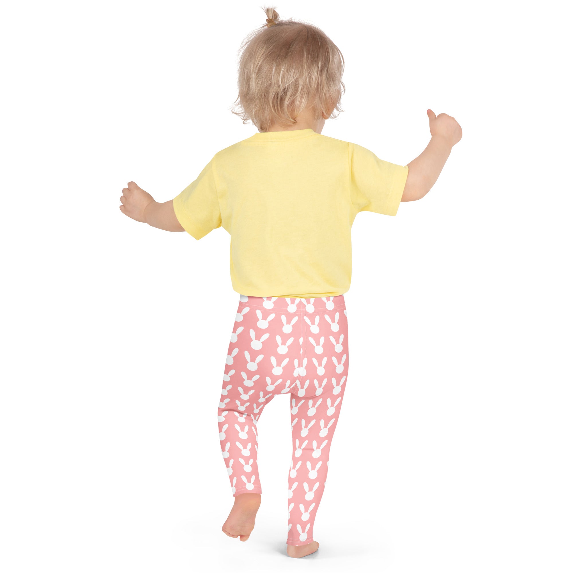 A child wearing girls pink Easter bunny buttery soft leggings with white bunny prints and a yellow short-sleeved shirt