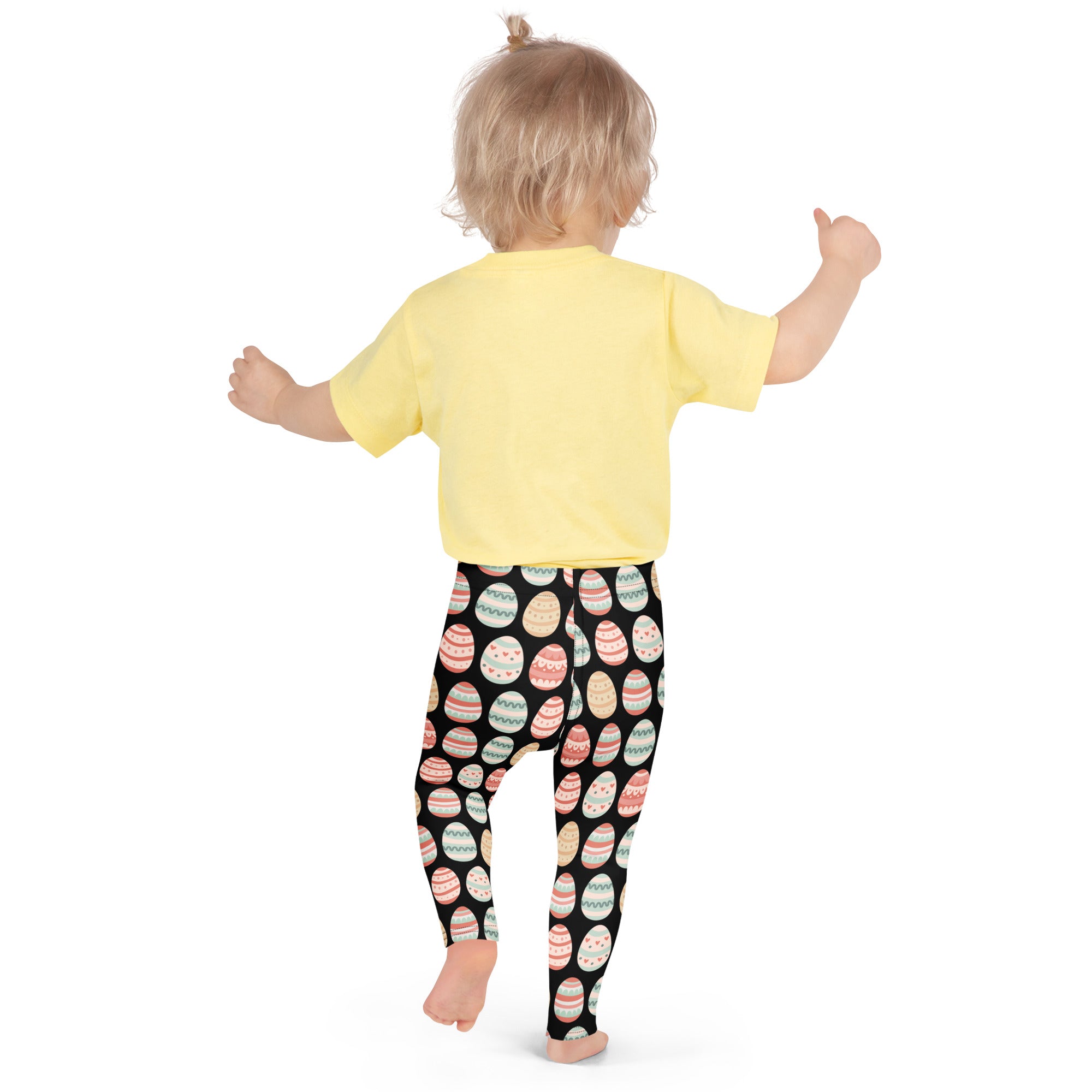 Girls black pastel easter egg buttery soft leggings featuring colorful decorated eggs worn with yellow short sleeve t-shirt
