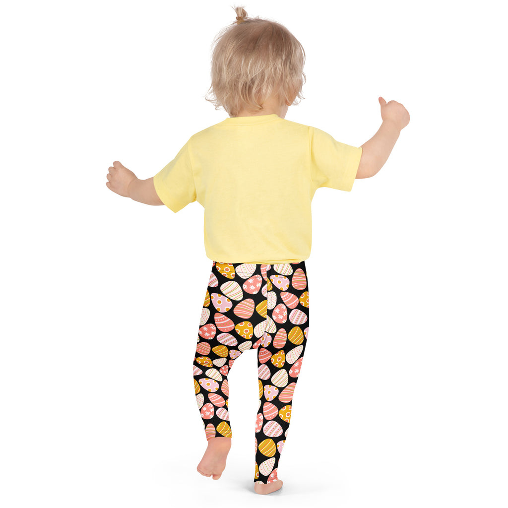 Yellow short-sleeved t-shirt paired with black girls bold easter egg buttery soft leggings with pastel gold eggs