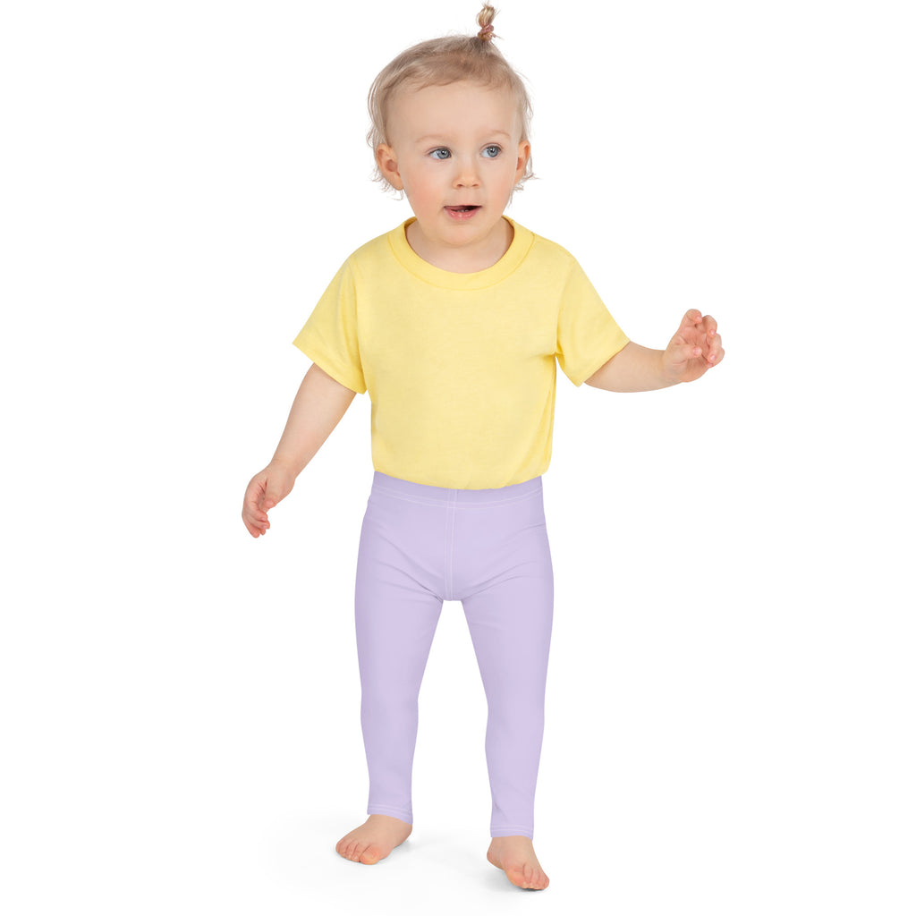 Toddler in pastel purple kids leggings and yellow t-shirt, standing on white background