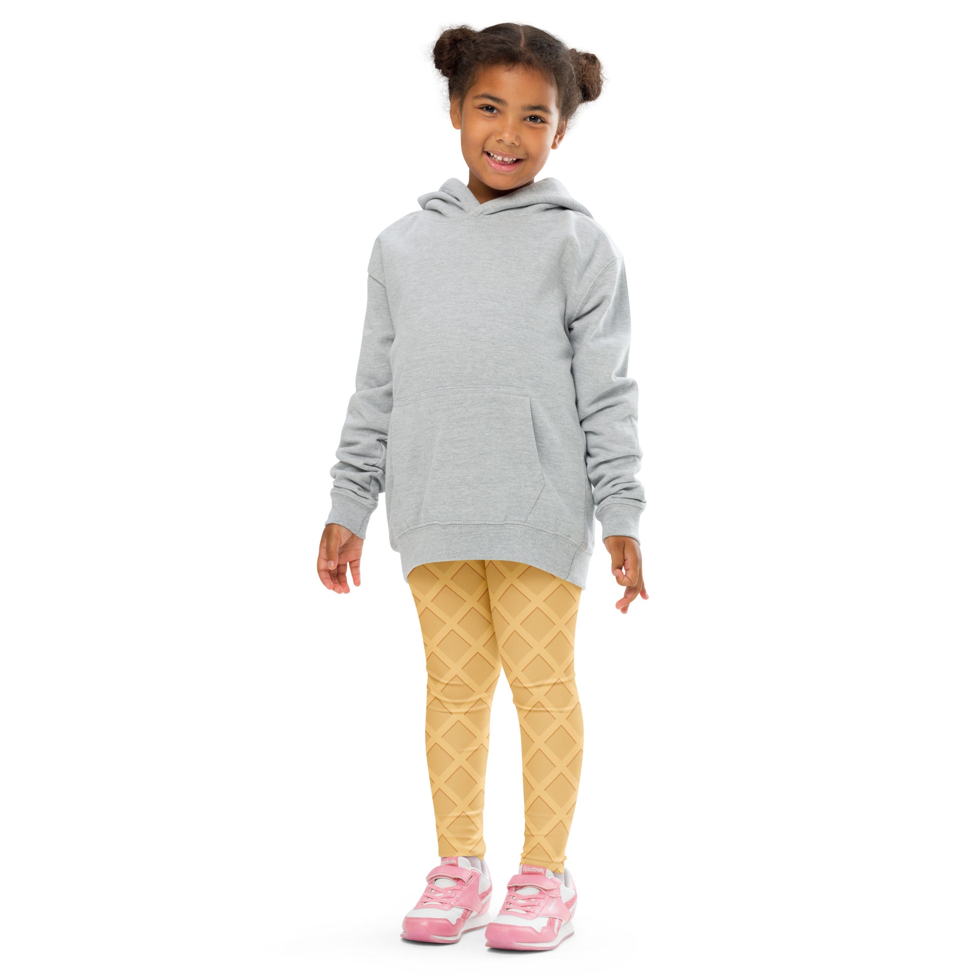 A child wearing buttery soft kids waffle cone yellow diamond patterned leggings with a light gray hooded sweatshirt