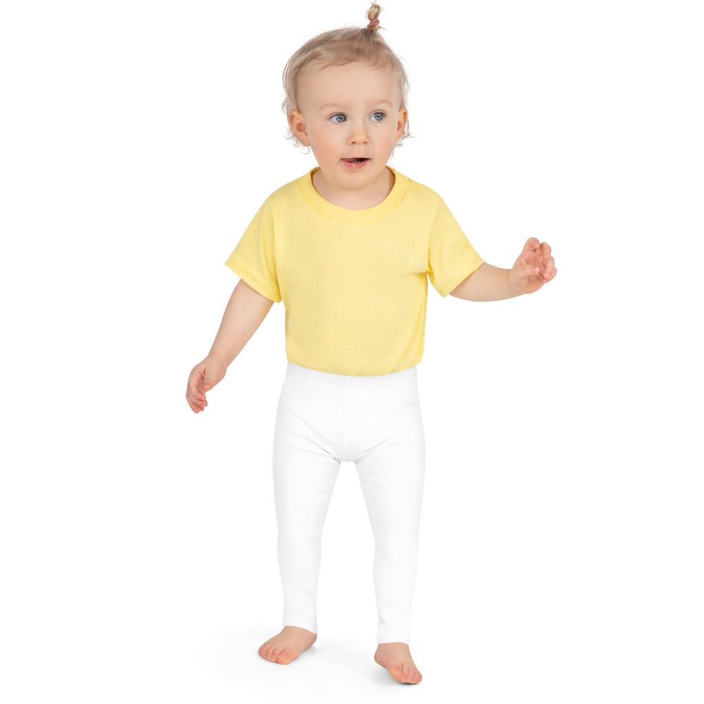 A toddler wearing kids buttery soft white leggings and a bright yellow short-sleeved t-shirt standing front view