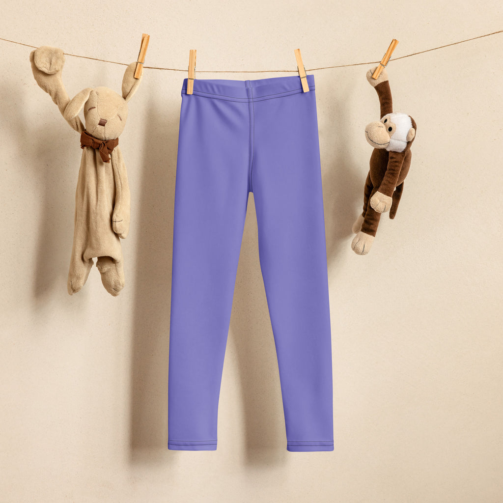 A pair of solid lavender girls buttery soft leggings hanging on a clothesline made from soft fabric