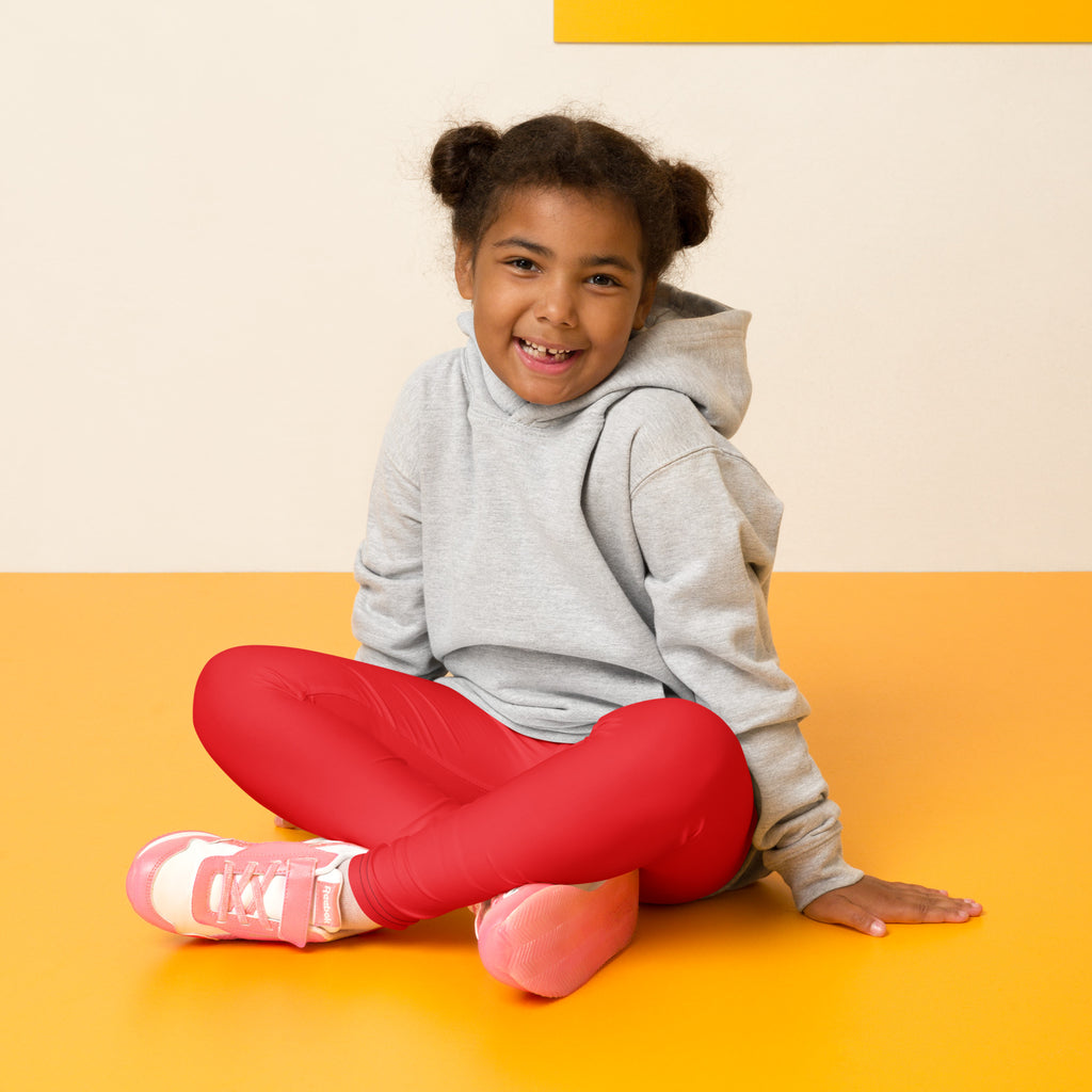 Pink and white athletic sneakers with velcro straps paired with kids buttery soft red leggings for active wear