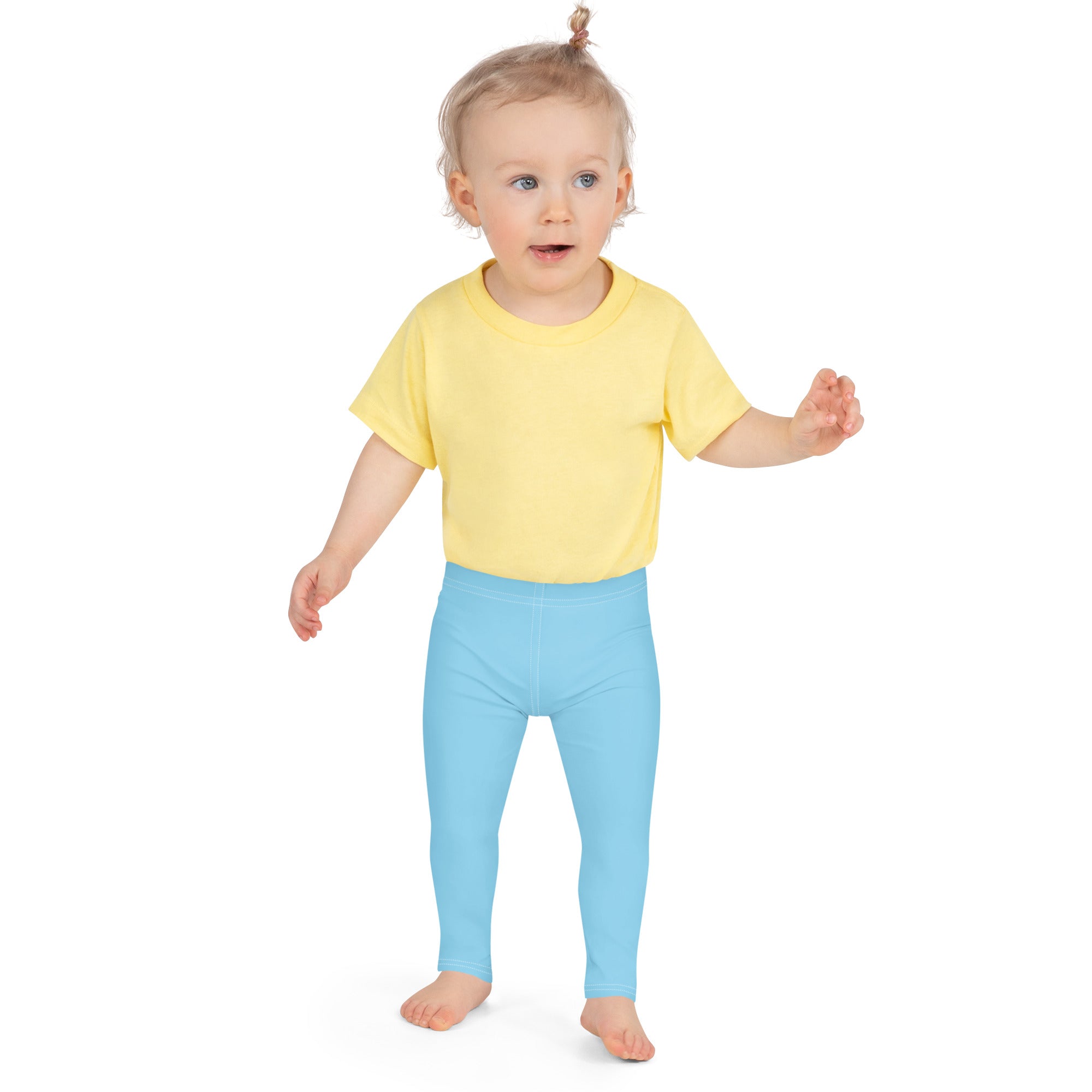 A toddler wearing buttery soft sky blue leggings made of comfortable fabric paired with a bright yellow tshirt