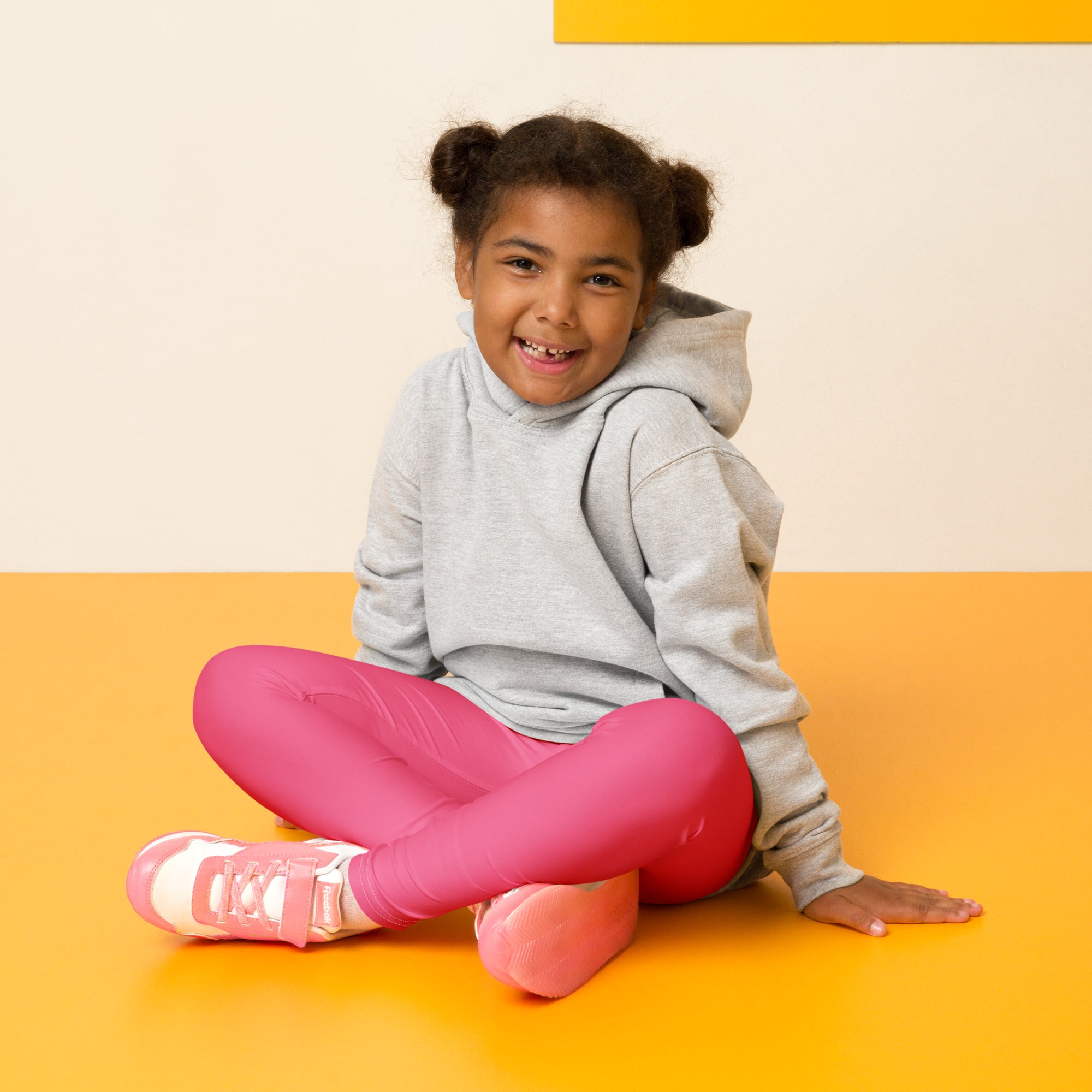 Pink athletic sneakers with white accents and pink laces paired with girls buttery soft pink leggings
