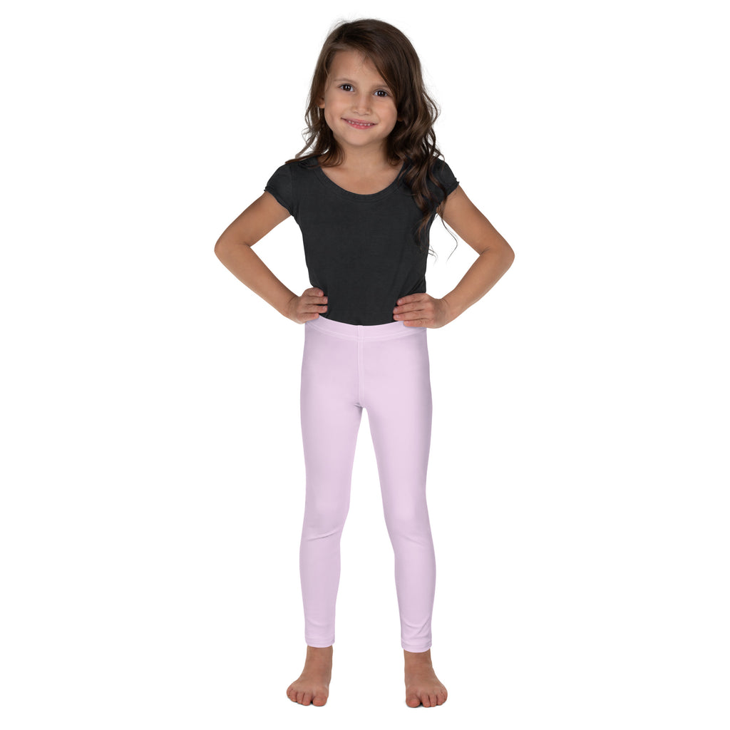 A young girl wearing a pair of buttery soft light pink form-fitting leggings designed for girls