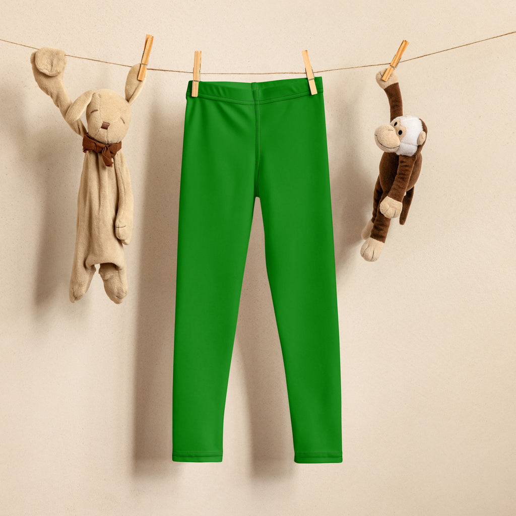 Bright green kids buttery soft leggings hanging on a clothesline showing their form-fitting design
