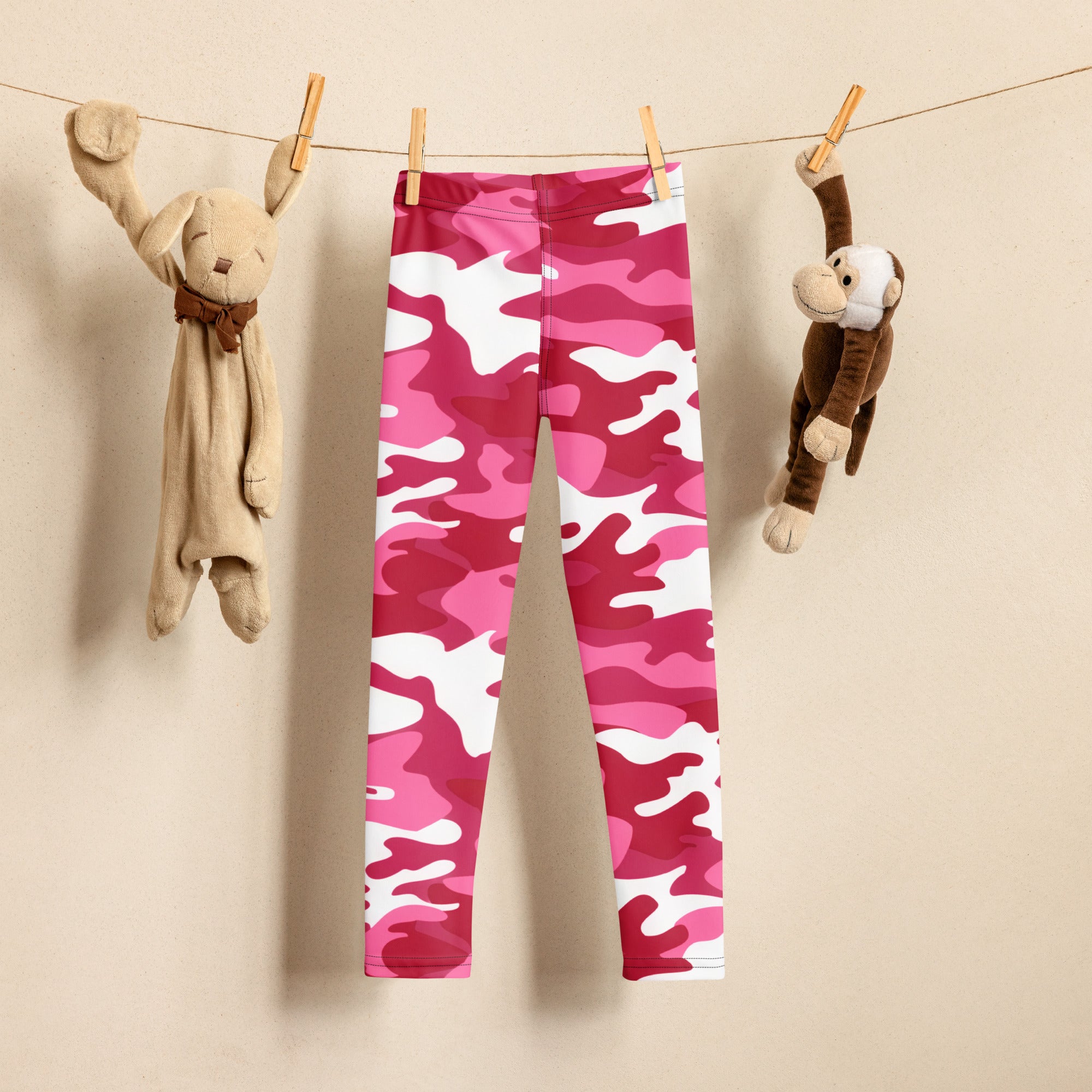Girls pink camouflage buttery soft leggings in pink and white hanging on a clothesline showing the front side