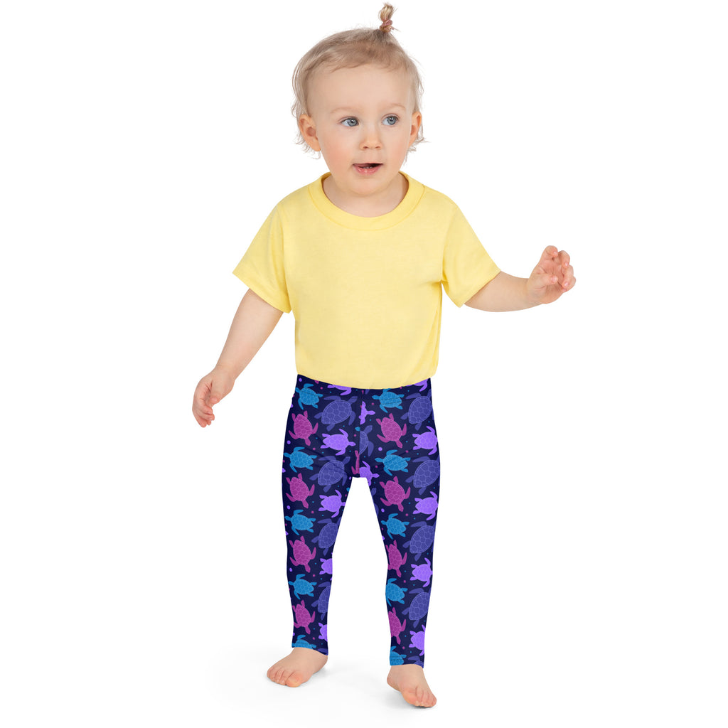 Child wearing girls purple sea turtle buttery soft leggings in navy blue with multicolored sea turtle pattern