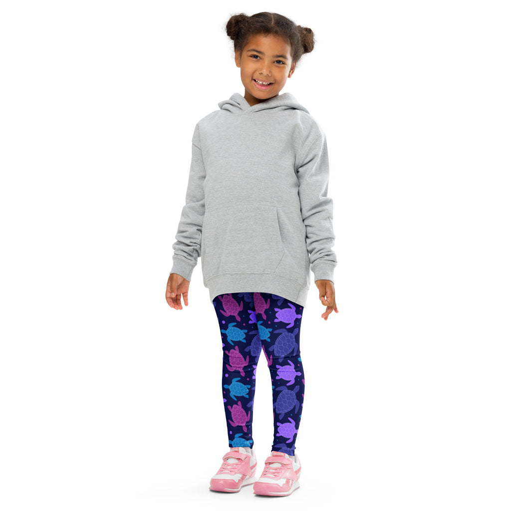 A child wearing girls purple sea turtle buttery soft leggings in dark blue with colorful sea turtle patterns