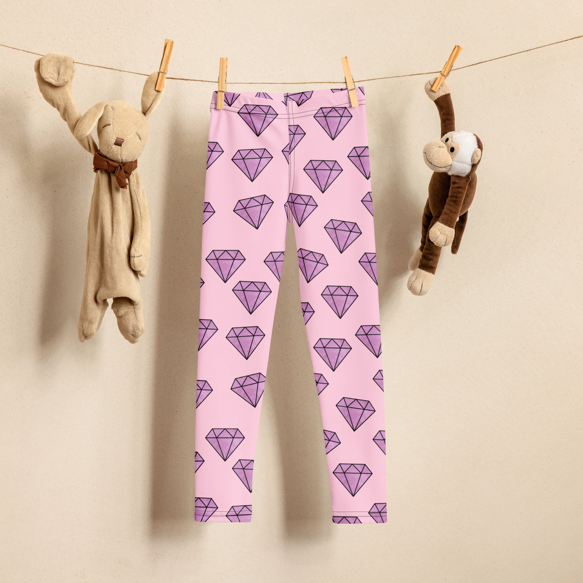 Pink girls buttery soft leggings with a repeating pattern of purple diamond shapes