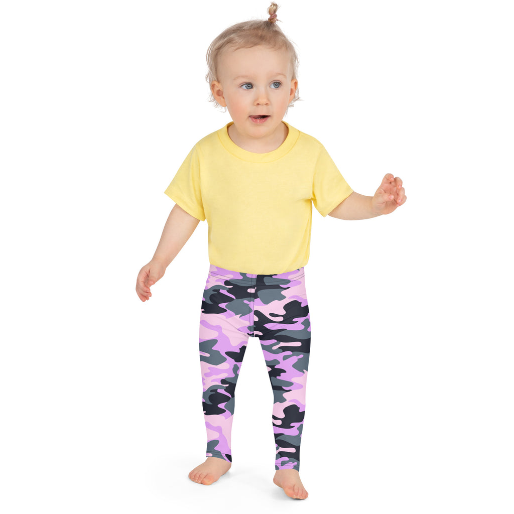 A toddler wearing girls purple camouflage buttery soft leggings with a yellow short-sleeved shirt