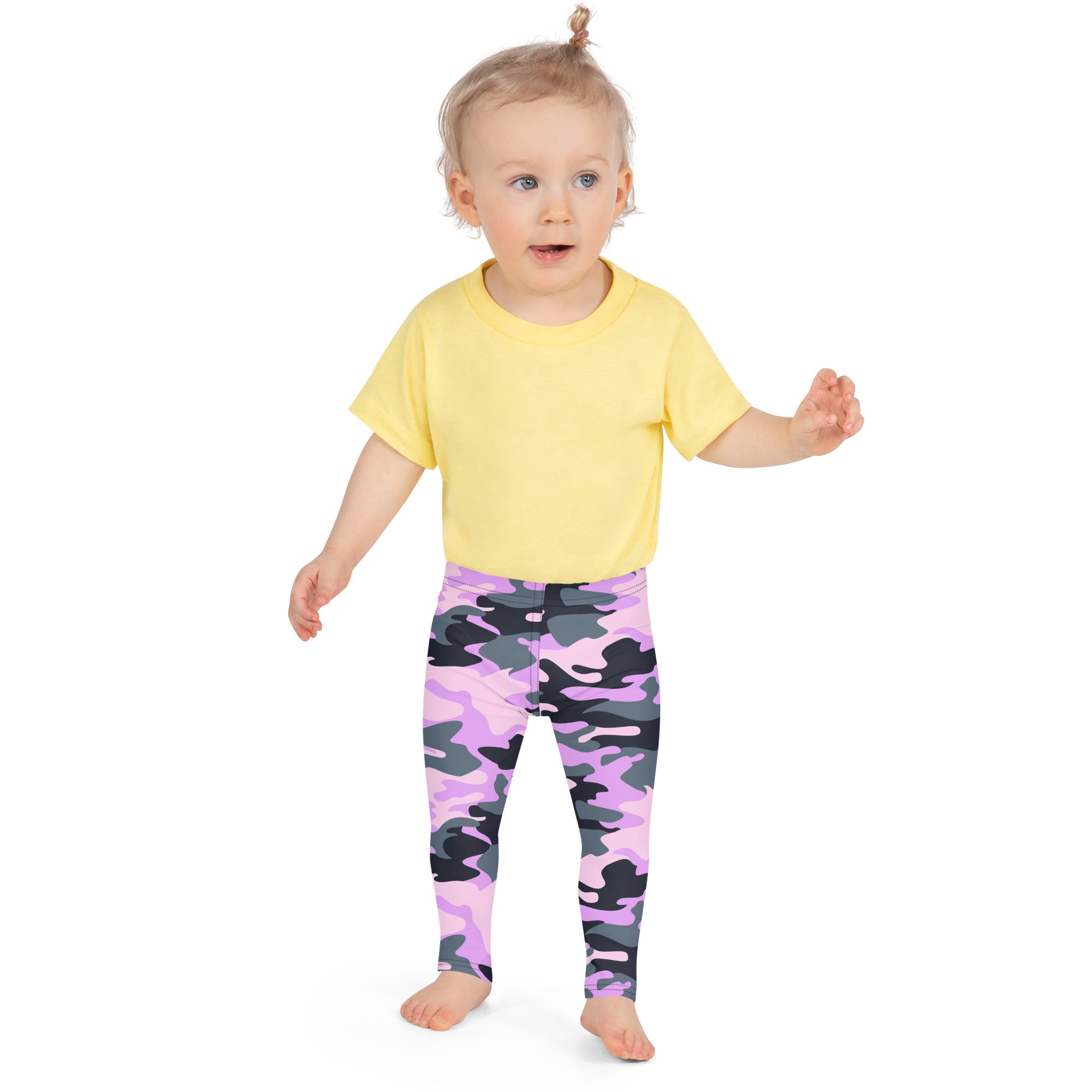 A toddler wearing girls purple camouflage buttery soft leggings with a yellow short-sleeved shirt