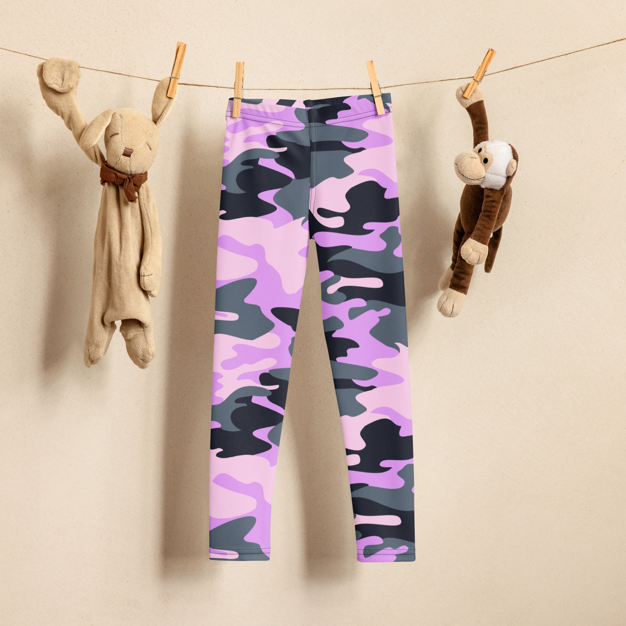 Girls purple camouflage buttery soft leggings in purple and gray hanging on a clothesline showing front view