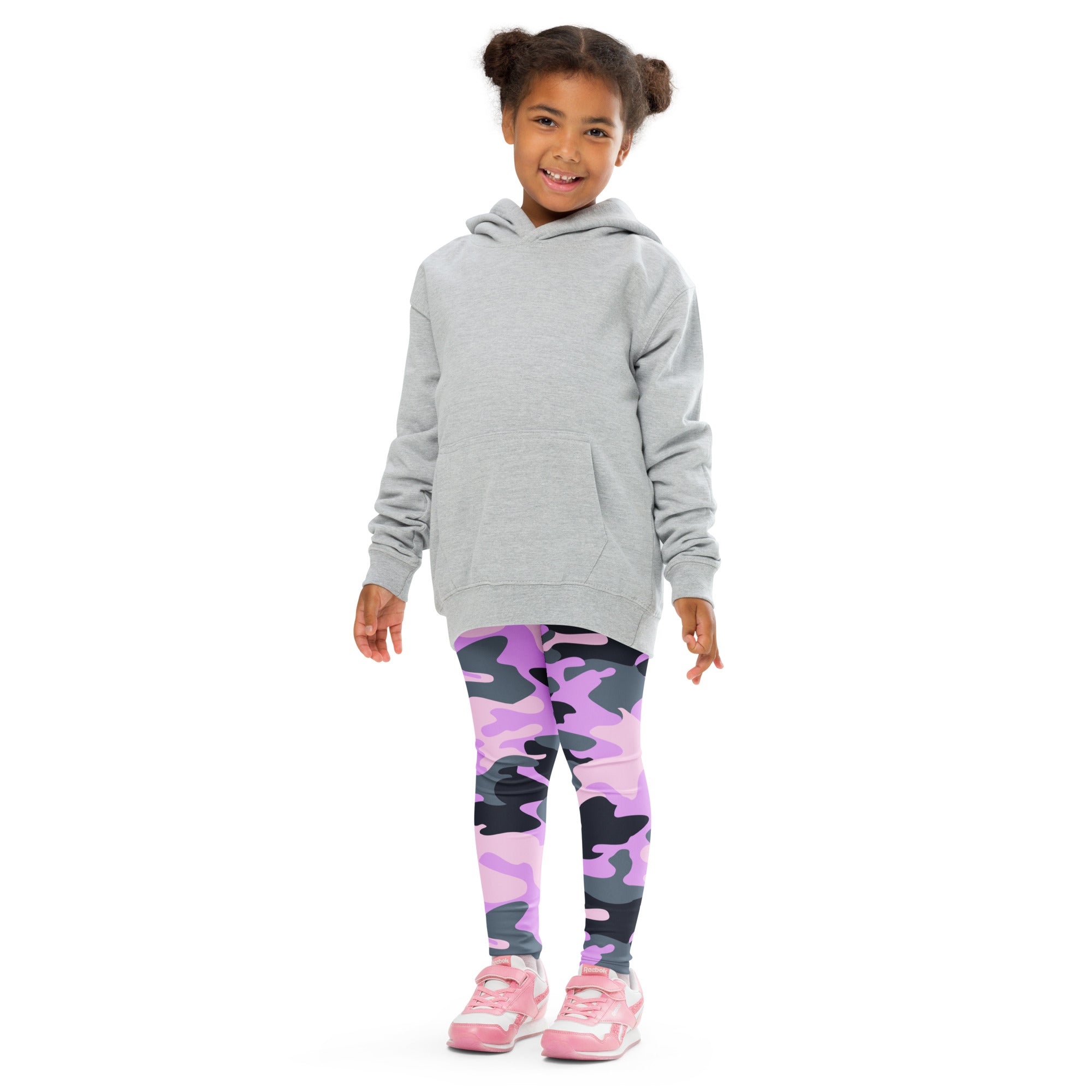 A young girl wearing girls purple camouflage buttery soft leggings and a light gray hooded sweatshirt