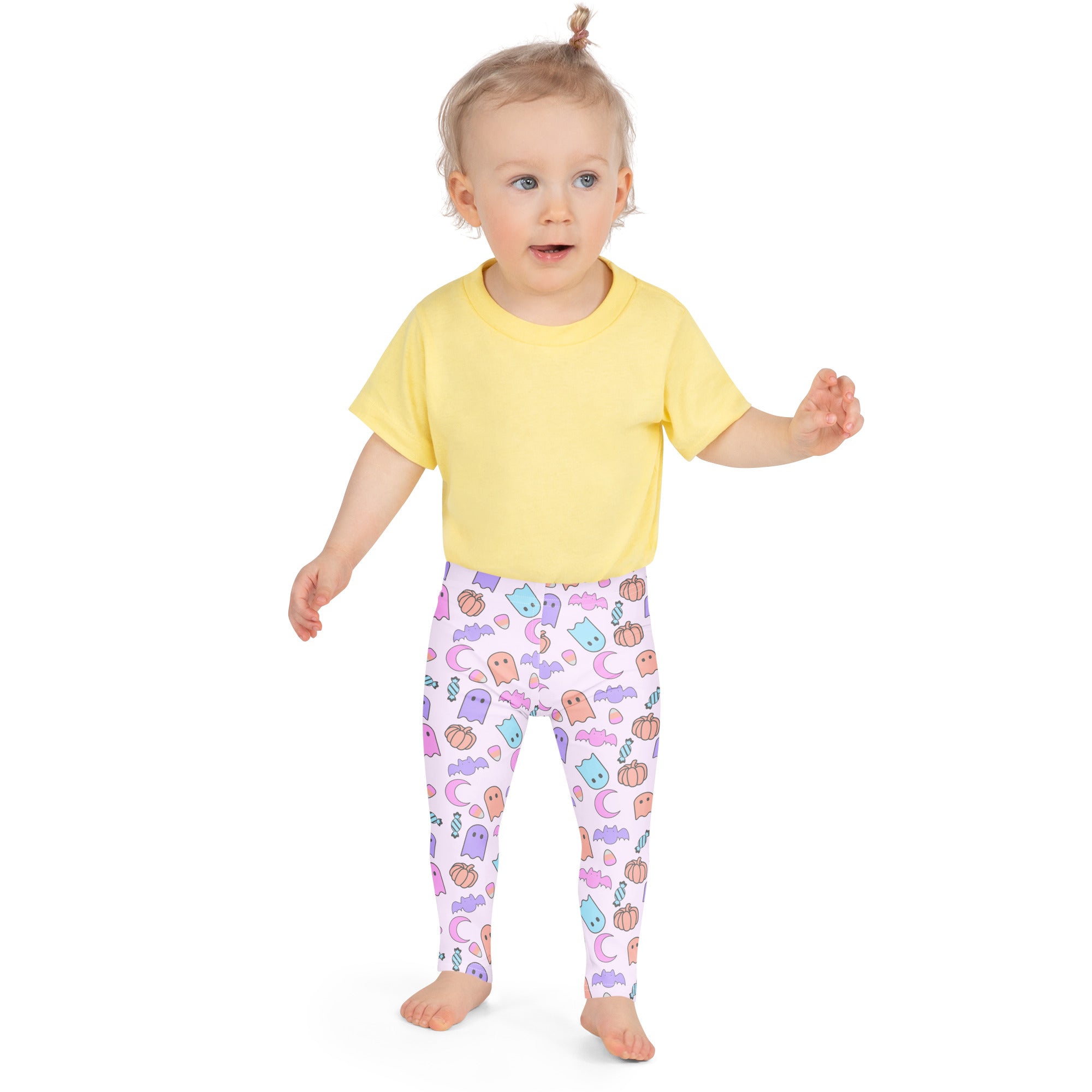 A child wearing buttery soft white leggings with colorful pastel halloween ghost pumpkin moon and bat patterns