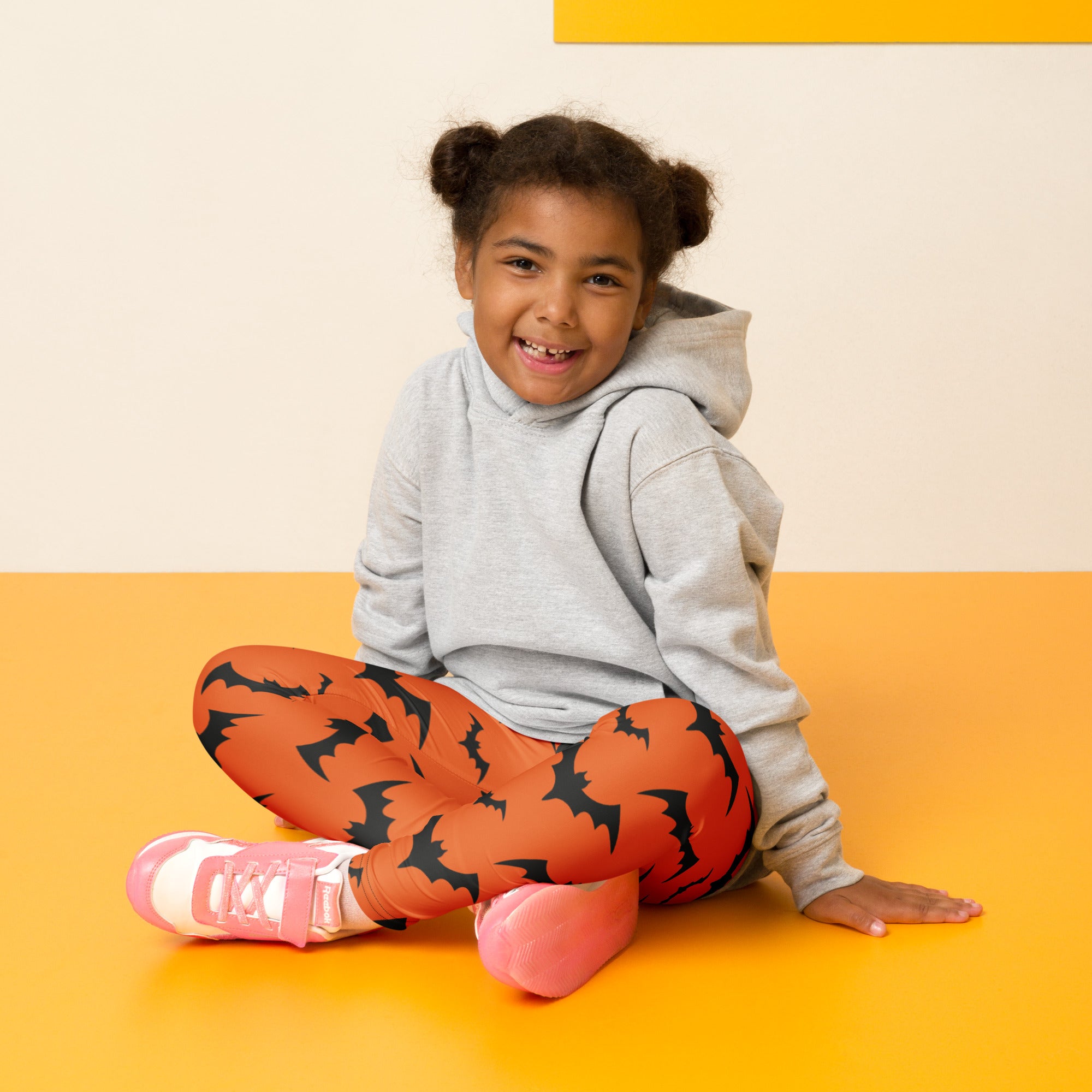 Kids orange buttery soft leggings with black bat patterns perfect for halloween dress-up and comfort
