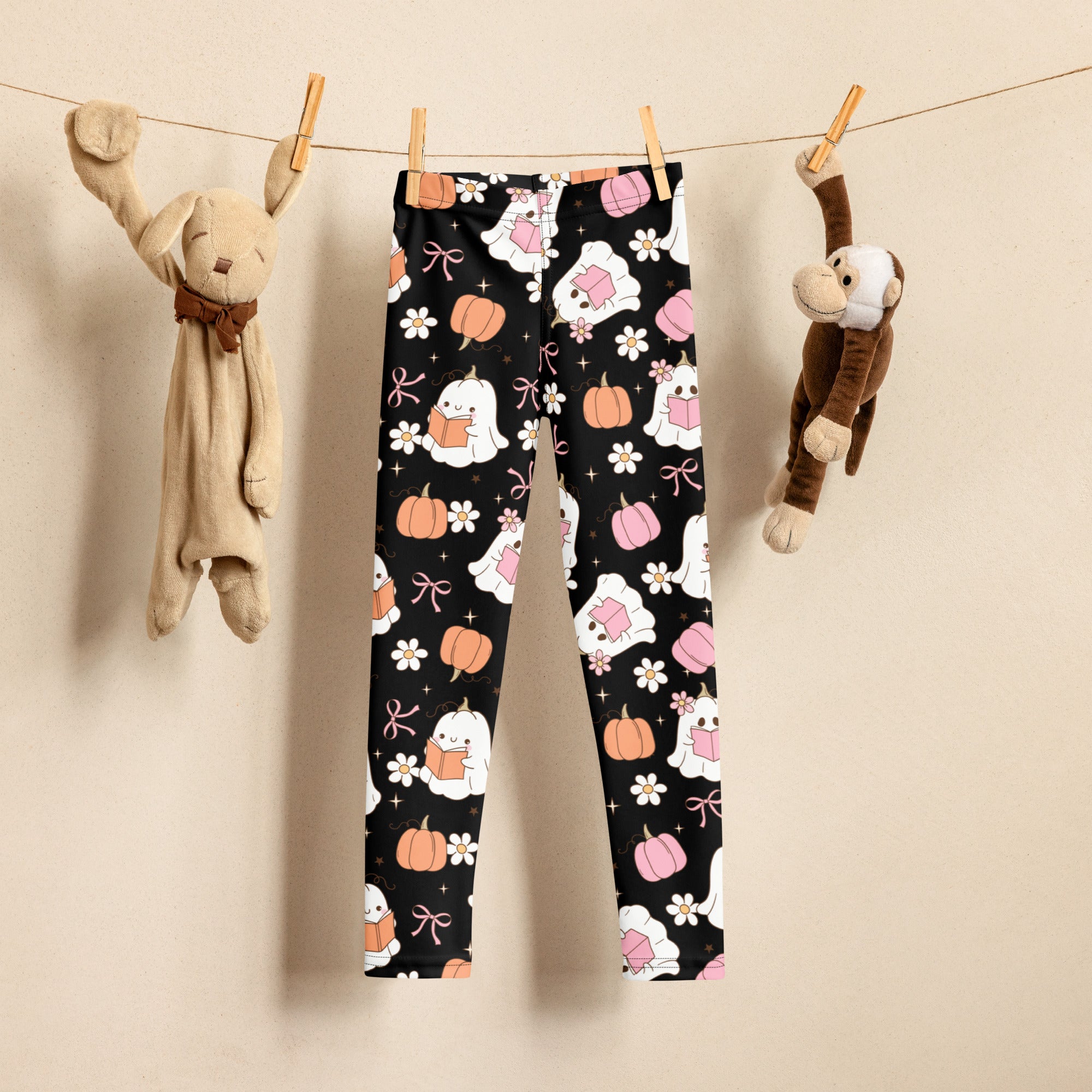 Black girls buttery soft leggings featuring a halloween pattern with white ghosts reading books pumpkins pink bows and flowers