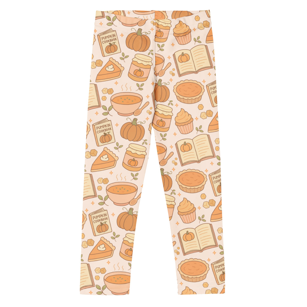 Cream-colored buttery soft kids leggings with playful autumn-themed pumpkin pie pattern including pumpkins pies and books
