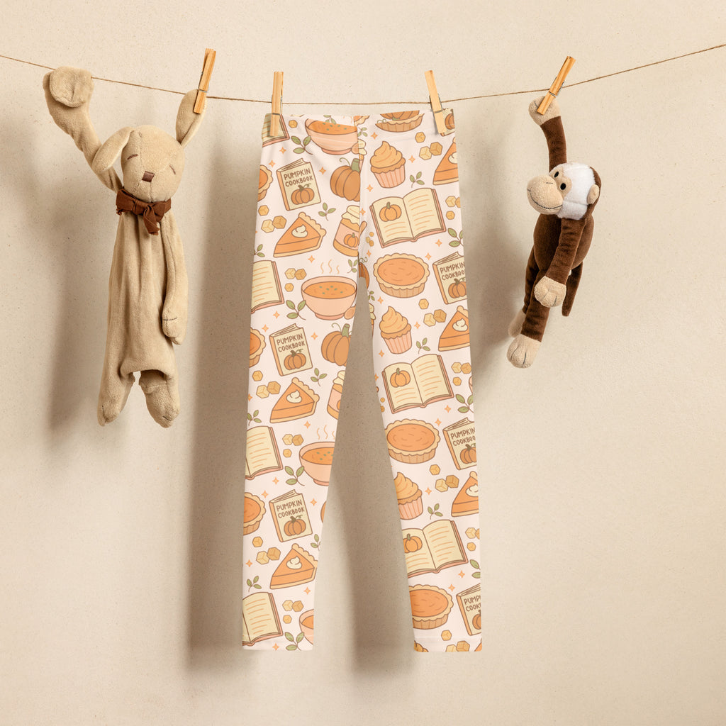 Kids pumpkin pie themed buttery soft cream-colored leggings with autumn pattern of pumpkin pie slices cupcakes and books