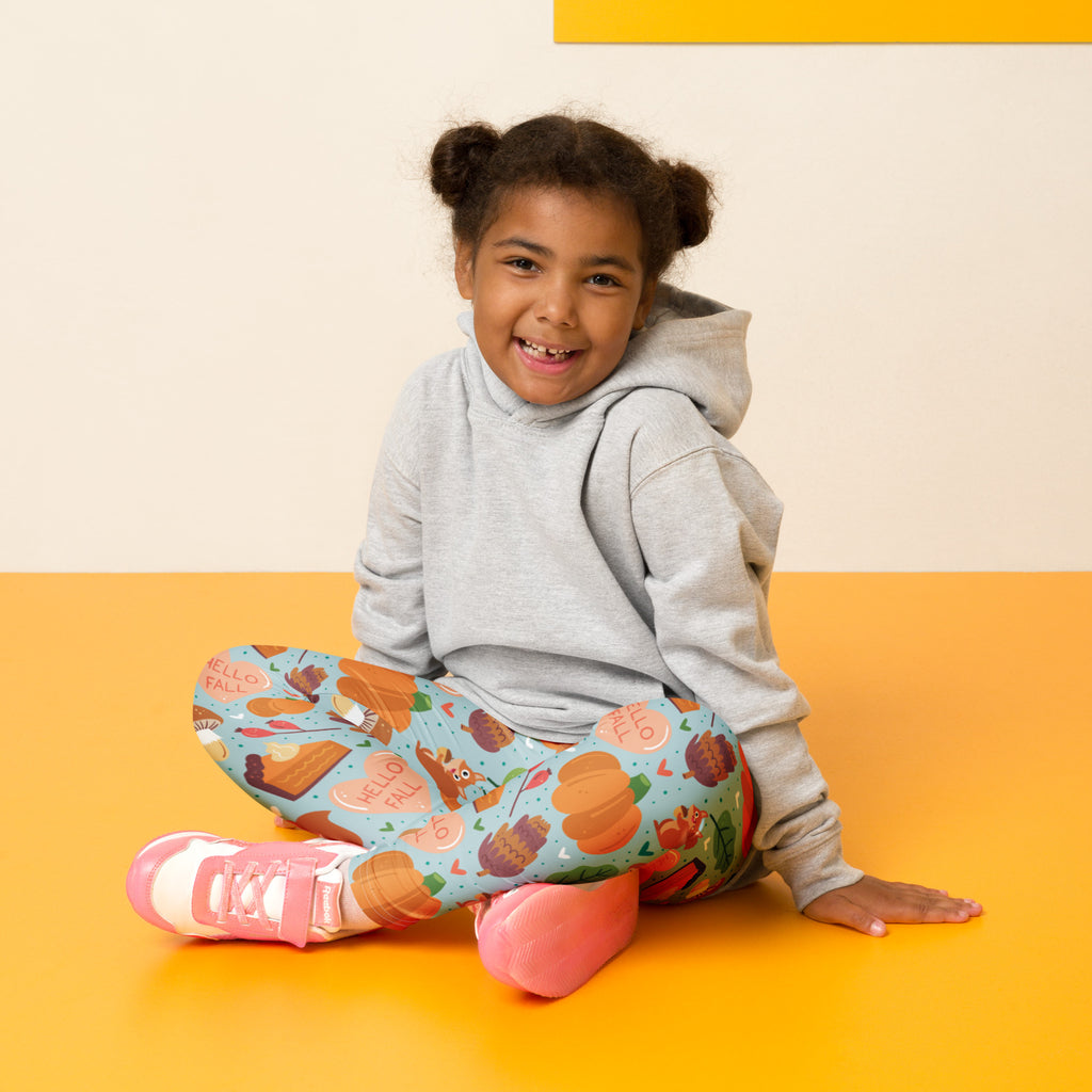A child wearing buttery soft gray hoodie and colorful girls hello fall autumn leggings with seasonal prints
