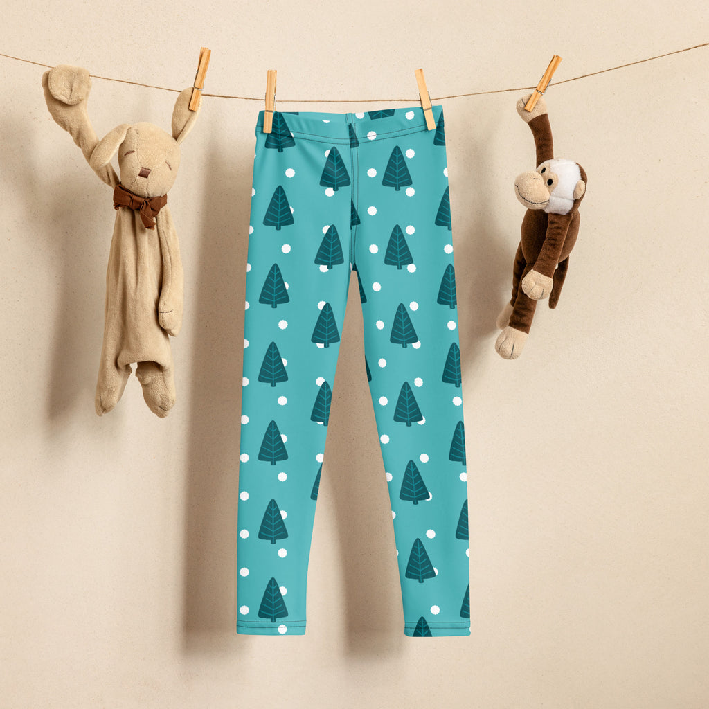 Teal kids christmas tree snow buttery soft leggings with dark green pine tree pattern and white polka dots hanging