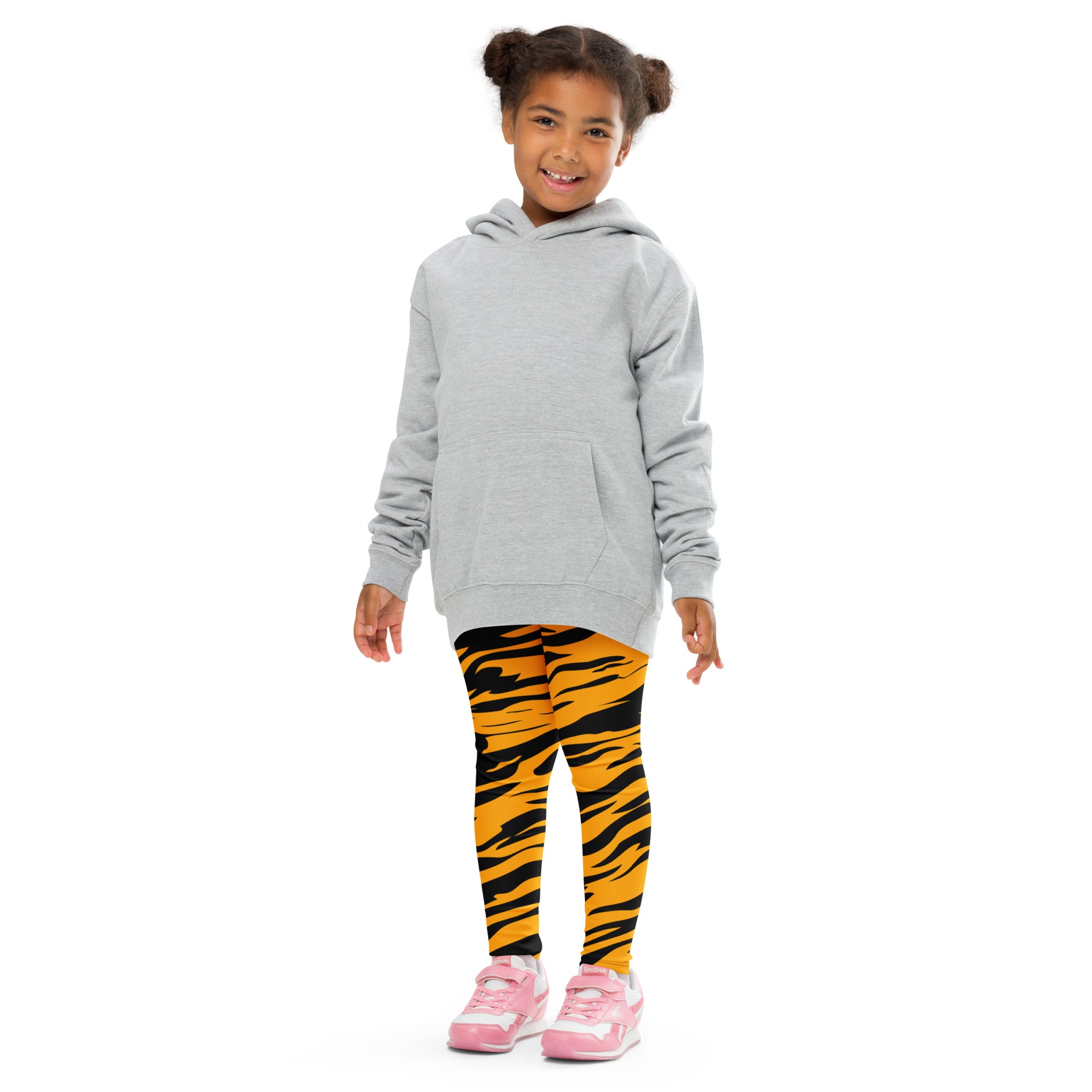 A child wearing kids tiger stripe buttery soft leggings in vibrant orange and black with a light gray hooded sweatshirt