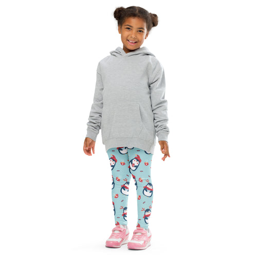 Girls cute penguin christmas buttery soft leggings in light blue with cartoon penguins worn with gray hooded sweatshirt