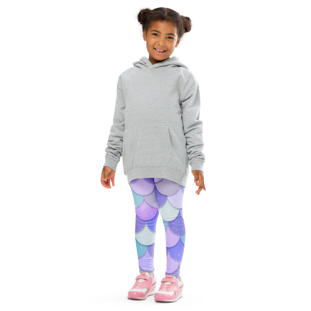 A child wearing girls purple mermaid buttery soft leggings with a mermaid-scale pattern and a light gray hooded sweatshirt