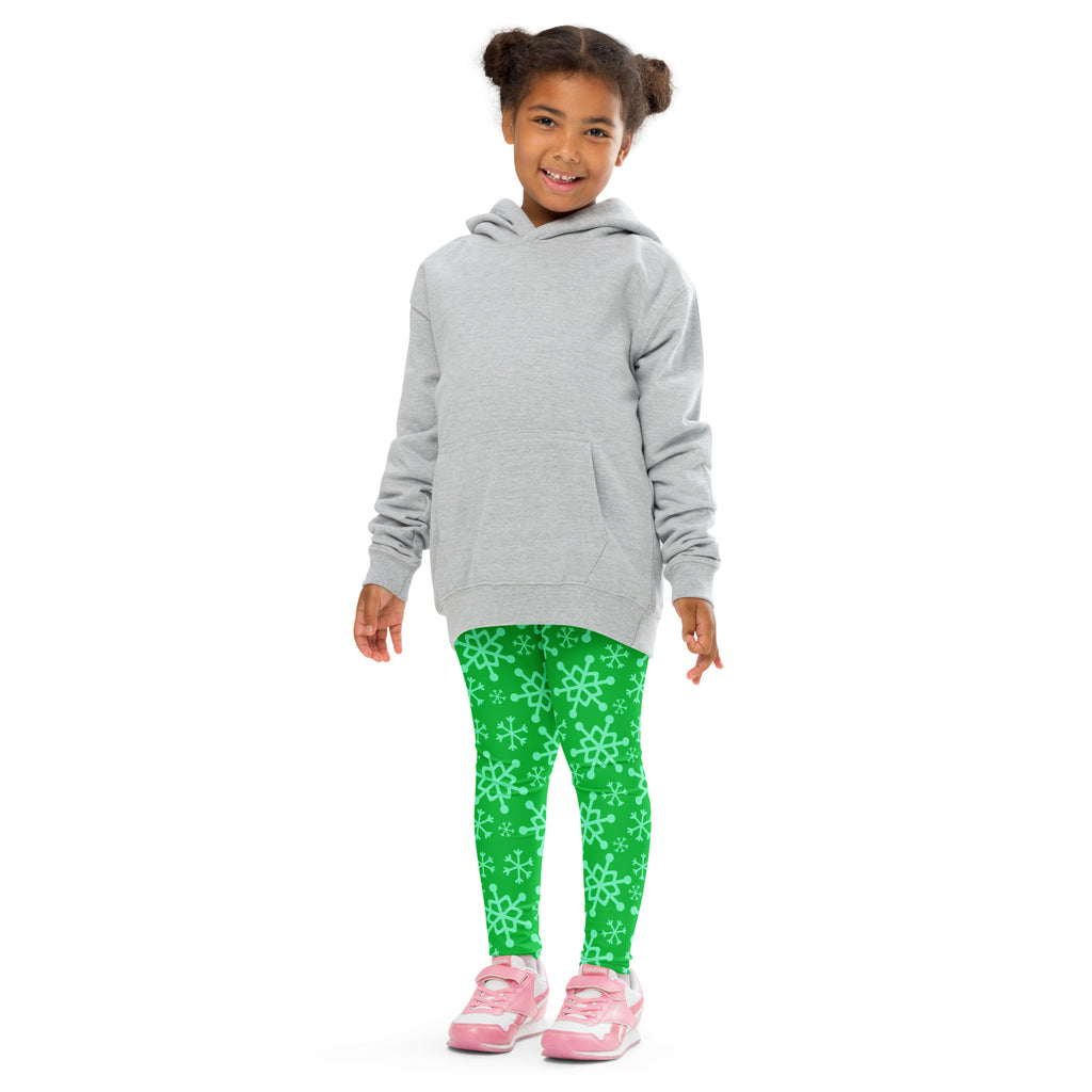 Kids green snowflake buttery soft leggings worn with a gray hooded sweatshirt with long sleeves and front pocket