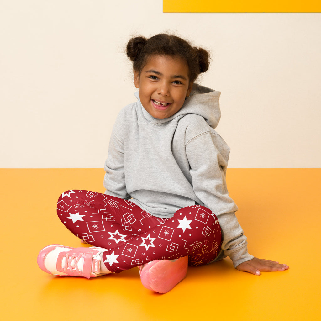 A child wearing kids red Hanukkah Star of David buttery soft leggings with white geometric star pattern