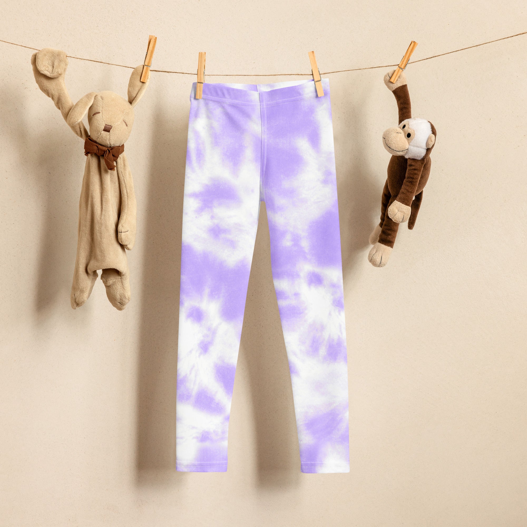 Girls lavender tie dye buttery soft leggings in purple and white hanging on a clothesline for drying