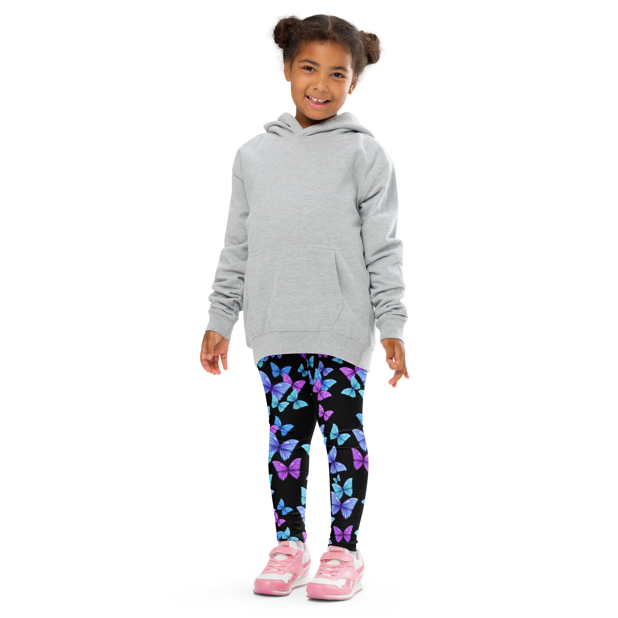 A child wearing girls vibrant butterfly buttery soft black leggings with blue and purple prints and a gray hooded sweatshirt