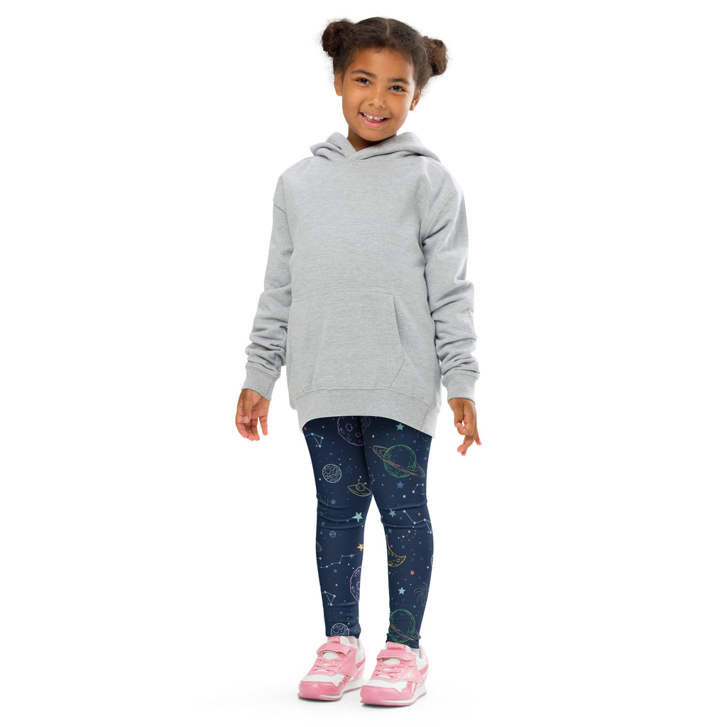 A child wears kids colorful galaxy space buttery soft dark blue leggings with celestial patterns and a light gray hooded sweatshirt