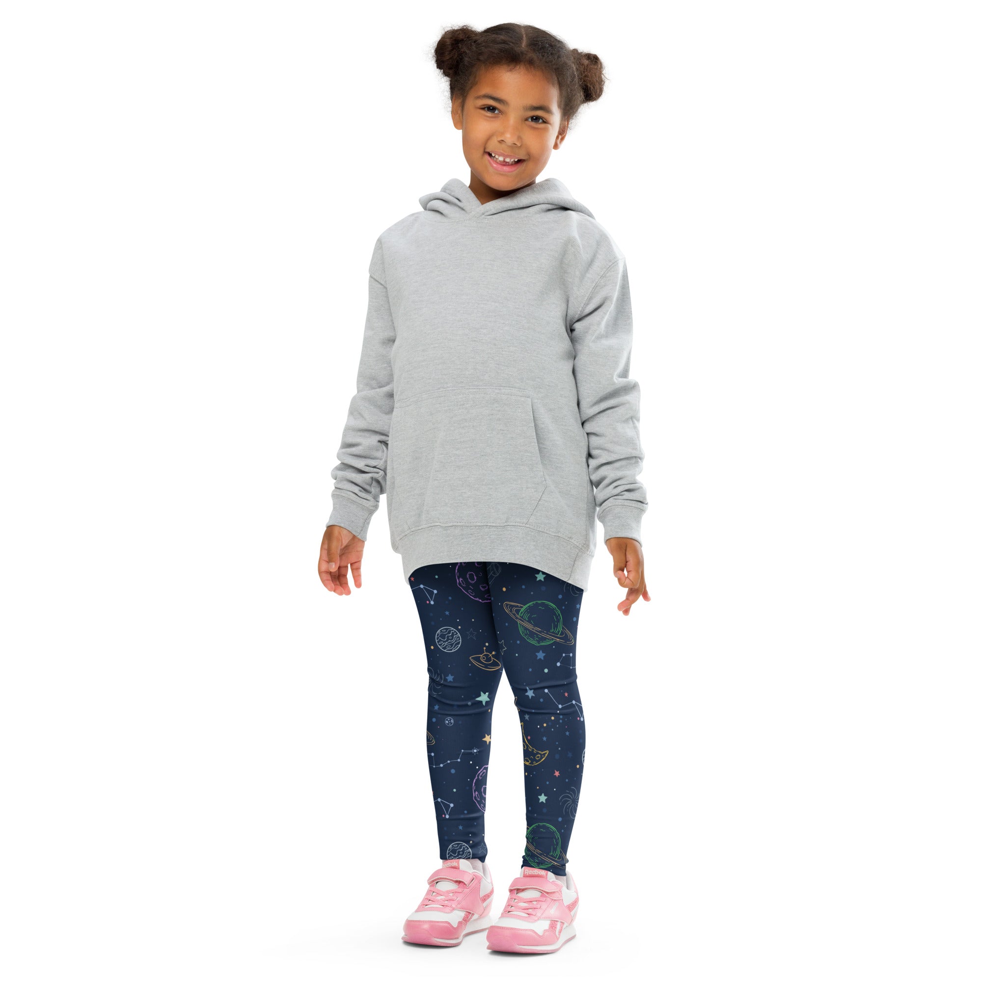 A child wears kids colorful galaxy space buttery soft dark blue leggings with celestial patterns and a light gray hooded sweatshirt