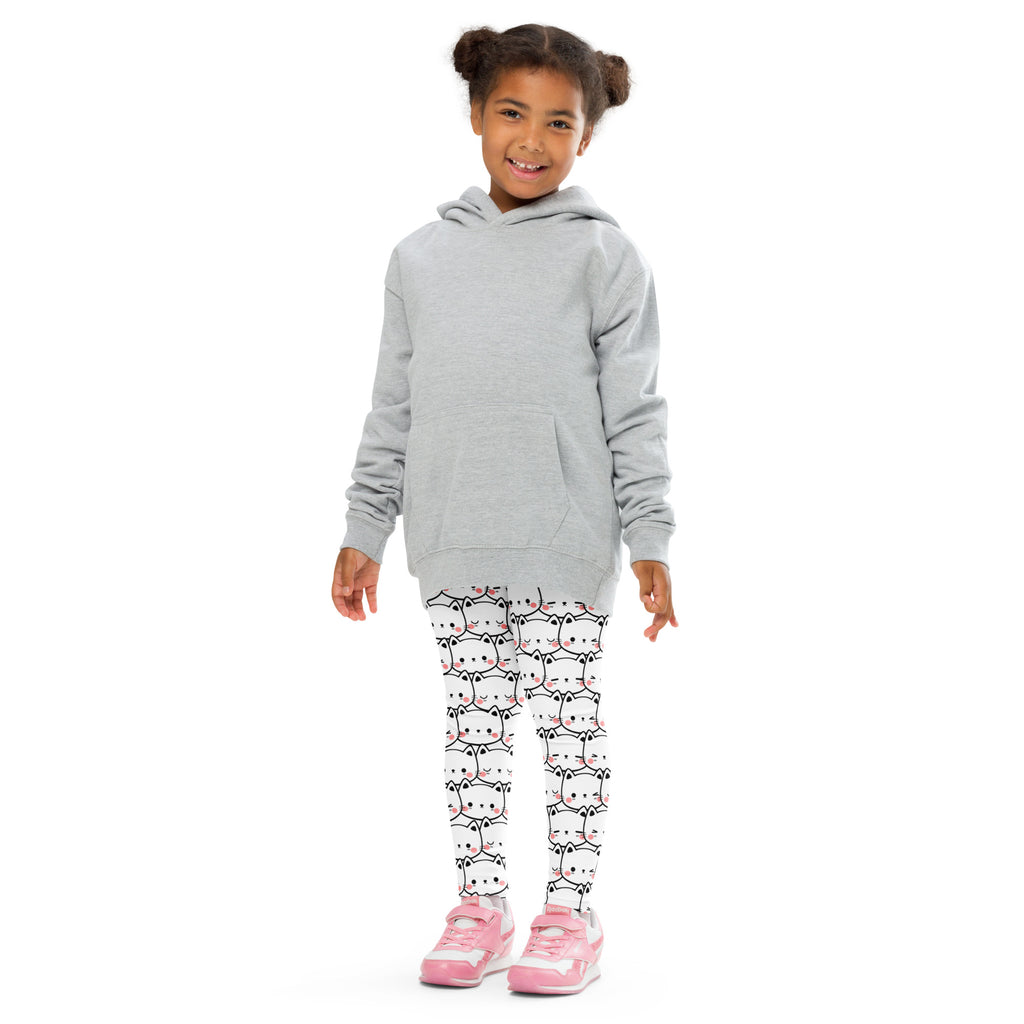 Girls white cat face buttery soft leggings with black and pink cartoon cat patterns worn with gray hooded sweatshirt